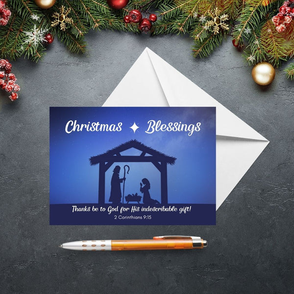 This Mary, Martha & Meg Christmas Greetings Card features a Nativity scene showing the silhouettes of Mary and Joseph in a stable, worshipping baby Jesus lying in a manger. A white star is set above the stable, contrasting with the inky blue sky. The greeting at the top of the card reads, ‘Christmas Blessings.’ The text underneath the Nativity scene is the treasured verse from 2 Corinthians 9:15, “Thanks be to God for His indescribable gift!”