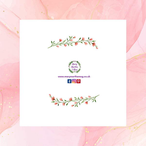 The reverse of a floral wreath greeting card by Mary, Martha & Meg photographed on a pale pink chiffon background with hints of gold swirls. The card shows the Mary, Martha & Meg logo at its centre, underneath are references to Mary, Martha & Meg social media sites. Above and below the images are a delicate spray of pink flowers and green leaves.
