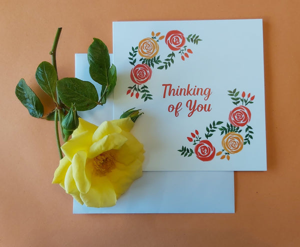 Thinking of You greeting card. Watercolour red and yellow rose design. Pictured with a yellow rose