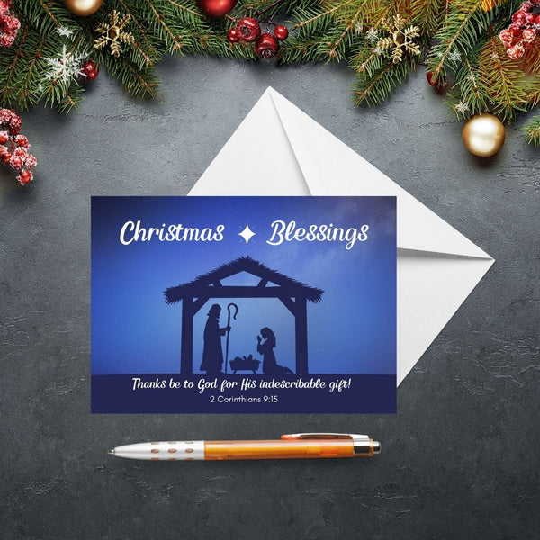 This Mary, Martha & Meg Christmas Greetings Card features a Nativity scene showing the silhouettes of Mary and Joseph in a stable, worshipping baby Jesus lying in a manger. A white star is set above the stable, contrasting with the inky blue sky. The greeting at the top of the card reads, ‘Christmas Blessings.’ The text underneath the Nativity scene is the treasured verse from 2 Corinthians 9:15, “Thanks be to God for His indescribable gift!” 