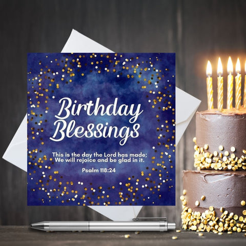 Midnight blue birthday blessing greeting card. Cream and white dots surround the white text. Text says, Birthday Blessings. This is the day that the Lord has made. We will rejoice and be glad in it. psalm 118:24. Brown wooden background with a chocolate birthday cake with candle to the side.