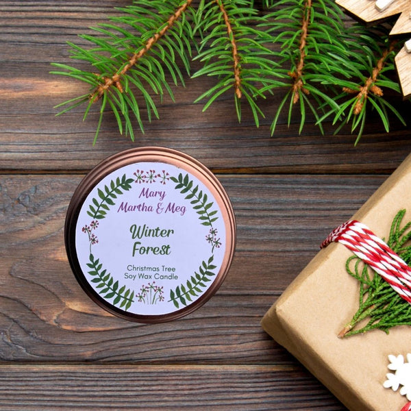 Mary, Martha & Meg 'Winter Forest' Soy Wax Candle . A lovely Christmas Tree Fragrance. The candle pic is taken from an aerial view of the  candle. The candle is on a dark varnished wood background with sprigs of fir tree in the top right corner.